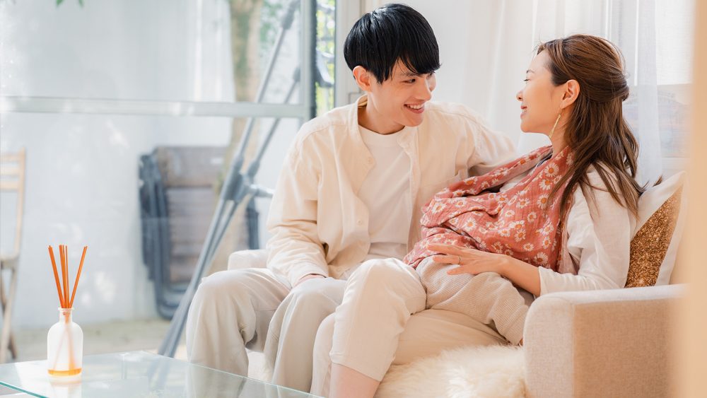 Mother breastfeeding her baby with father